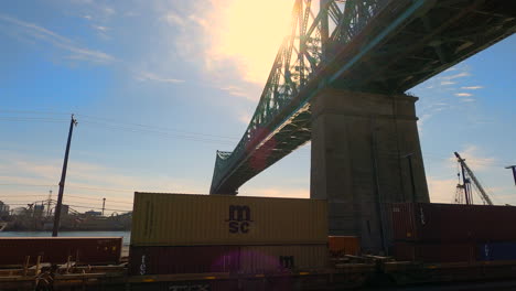 Tren-De-Carga-Bajo-El-Puente-De-Acero-Jacques-Cartier-Ciudad-De-Montreal,-Canadá,-Estructura-Elevada-Metálica-Rígida-Urbana-Para-El-Transporte,-Vista-Inclinada-Hacia-Arriba-De-La-Infraestructura-Arquitectónica-Y-La-Ingeniería