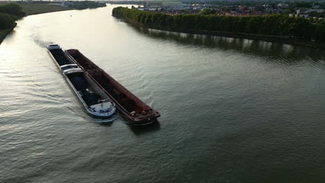 Luftaufnahme-über-Den-Amoureus-Schubfrachter,-Der-Bei-Sonnenuntergang-Entlang-Der-Beneden-Merwede-Segelt