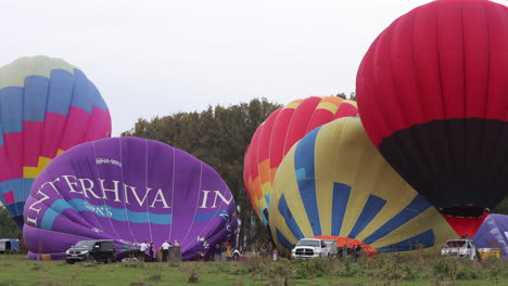 Grupos-De-Personas-Inflando-Globos-Aerostáticos,-Preparándose-Para-El-Lanzamiento