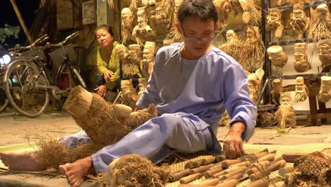 Hombre-Vietnamita-Tallando-Caras-De-Madera-De-Raíz-De-Bambú-En-La-Calle-En-Hoi-An