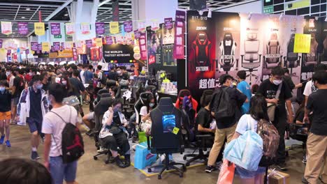Chinese-visitors-and-retail-tech-buyers-browse,-test,-and-buy-gaming-chairs-during-a-Computer-and-Communications-Festival-as-shoppers-look-for-discounted-electronics-and-accessories-branded-products