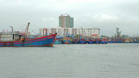 A-wooden-fishing-boat-passes-slowly-across-the-marina-on-a-stormy,-blustery-day