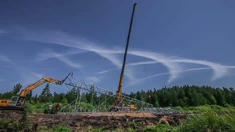 Zeitraffer-Von-Bauarbeitern-Und-Kränen,-Die-Einen-Stromturm-In-Einer-Ländlichen-Landschaft-Mit-Seltsamen-Kreisförmigen-Wolken-Am-Himmel-Errichten