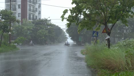 Lluvia-Torrencial-Tormentosa,-Viento-Fuerte-Y-Escena-De-Tifón-Entrante,-Gente-Montando-Motos-En-Carretera-Mojada-En-La-Ciudad-De-Da-Nang,-Vietnam