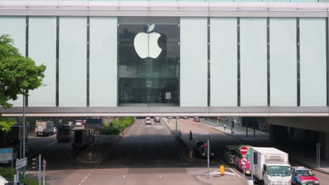 Se-Ve-Tráfico-Conduciendo-A-Través-De-Una-Empresa-De-Tecnología-Elevada,-Apple,-Tienda-Oficial-En-Hong-Kong