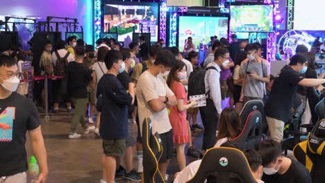 Chinesische-Besucher-Und-Einkäufer-Von-Technologie-Im-Einzelhandel-Stöbern,-Testen-Und-Kaufen-Gaming-Stühle-Während-Eines-Computer--Und-Kommunikationsfestivals,-Während-Käufer-Nach-Ermäßigten-Markenprodukten-Für-Elektronik-Und-Zubehör-Suchen