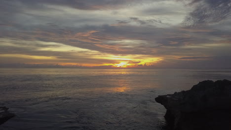 Romantic-man-woman-couple-reflect-in-pool,-looking-out-to-ocean-sunset