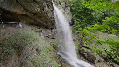 Gente-En-El-Puente-Bajo-La-Cascada-De-Geissbach-En-Suiza