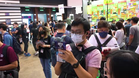 Crowds-of-Chinese-retail-tech-customers,-shoppers,-and-visitors-pack-the-halls-as-they-browse-and-buy-discounted-electronic-products,-such-as-hard-drives,-TVs,-and-laptops,-at-a-computer-festival