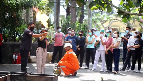 Yogyakarta,-Indonesia---Sep-24,-2022-:-Asian-young-woman-practicing-how-to-extinguish-a-fire-on-a-gas-stove-leak