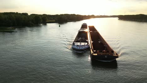 Aerial-Parallax-Left-Around-Forward-Bow-Of-Amoureus-Push-Freighter-Sailing-Along-Beneden-Merwede-During-Sunset