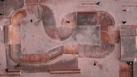 Overhead-Shot-Of-Board-Riders-In-Ericeira-Skate-Park,-Beautiful-Ground-Design,-Portugal