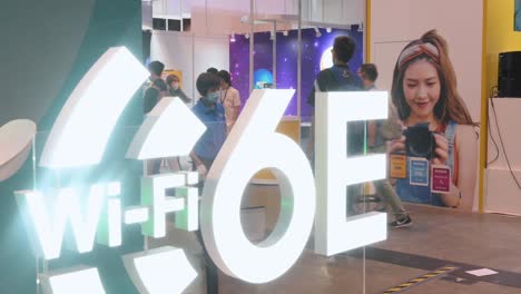 Los-Visitantes-Chinos-Pasan-Frente-A-Un-Stand-Que-Muestra-El-Logotipo-De-Internet-De-Alta-Velocidad-Wifi-6e-Durante-El-Festival-De-Computadoras-Y-Comunicaciones-De-Hong-Kong-En-Hong-Kong