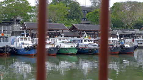 Blick-Durch-Den-Stahlzaun-Auf-Bumboats,-Die-Am-Changi-Steg-In-Singapur-Geparkt-Sind