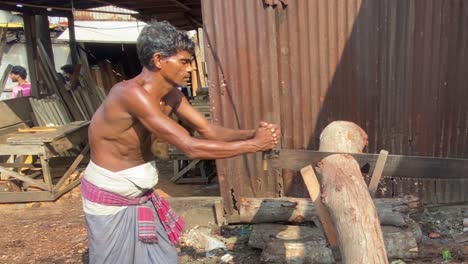 Hemdloser-Männlicher-Bangladesch,-Der-Longyi-Trägt,-Der-Holzsäge-Im-Holzplatz-Verwendet