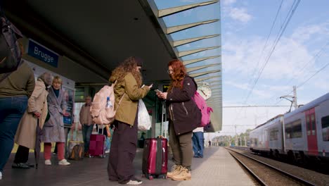 Passengers-waiting-for-train-arrival-at-the-railway-station-of-Bruges,-Belgium