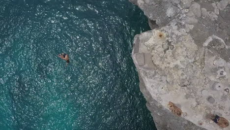 Steigende-Slo-Mo-Antenne-über-Dem-Kopf,-Während-Die-Klippe-Mit-Einer-Drehung-Ins-Meer-Springt