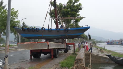 Menschen-Mit-Kran-Bei-Starkem-Regen-Verlegen-Boot-Aus-Dem-Meer-Vor-Tropischem-Sturm,-Stadt-Da-Nang,-Vietnam