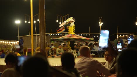 El-Hombre-Local-Realiza-Danza-Folclórica-Tradicional-Por-La-Noche-Como-Parte-De-Un-Espectáculo-De-Safari-Por-El-Desierto,-Dubai