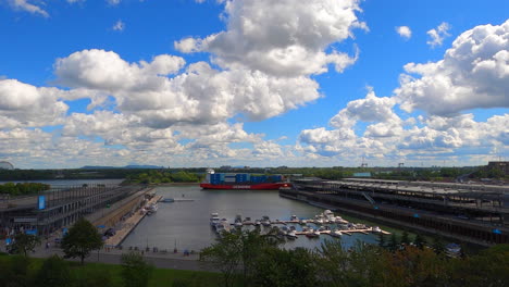 Cargo-Boat-Ferry-Sailing-on-River-Canal-next-to-Marina-at-Montreal-Port-Harbor-Canada,-Panoramic-View-of-Pier-Docks-and-Yachts-on-Water,-Freight-Transport-Zoom-in-View