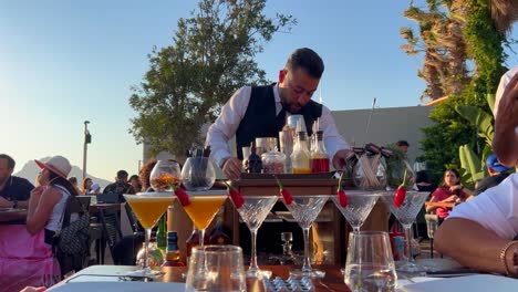 Servicepersonal-Am-Tisch,-Das-Frische-Cocktails-Im-Restaurant-Nusret-Salt-Bae-Im-Hafen-Von-Yalikavak-Zubereitet-Und-Einschenkt,-Luxuriöses-Speiseerlebnis-In-Einem-Berühmten-Restaurant-In-Bodrum,-Türkei,-4k-Aufnahme