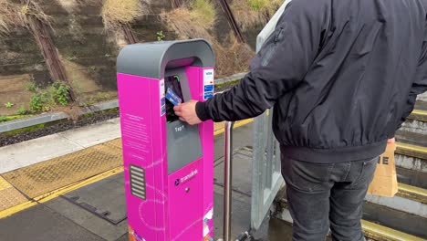 Männlicher-Passagier,-Der-Am-Fahrkartenautomaten-Am-Bahnhof-Bowen-Hills-Tippt-Und-Mit-Der-Go-karte-Den-Ermäßigten-Fahrpreis-Bezahlt,-Brisbane,-Queensland,-Australien