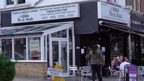 Pastel-De-Petirrojos-Y-Tienda-De-Puré-En-Wanstead-High-Street-Con-Gente-Caminando