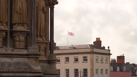 Bandera-Union-Jack-Temblando-En-El-Ala-En-El-Fondo-De-Una-De-Las-Torres-De-La-Catedral-De-Pozos,-Cámara-Estable,-4k