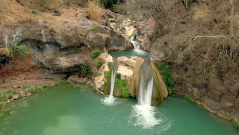 Aerial-View-Of-Couple-Going-To-The-Natural-Pool-Of-Cascada-de-Comala-Park-In-Chiquilistlan,-Mexico