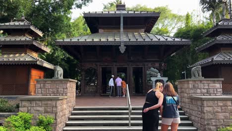 Point-of-view-handheld-shot-walking-towards-the-three-story-high-nepalese-pagoda-in-South-Bank,-tourists-visiting-the-attraction-at-heart-of-the-Parklands,-South-Bank-Brisbane,-Queensland,-Australia