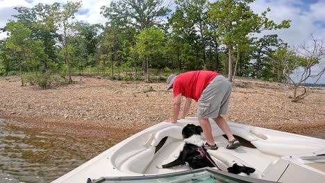 Couple-shore-docking-their-sports-boat-on-a-graveled-shore-in-Table-Rock-Lake-in-Missouri-USA