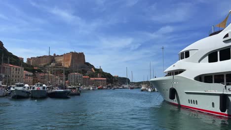 Gran-Yate-Lujoso-Y-Caro-Amarrado-En-El-Puerto-De-Bonifacio-Con-Castillo-Y-Ciudadela-Encaramado-En-Un-Acantilado