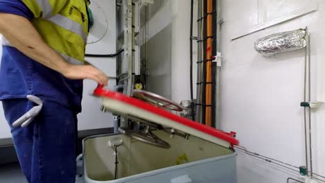 Static-shot-of-a-boat-worker-turning-the-handle-and-opening-the-hatch