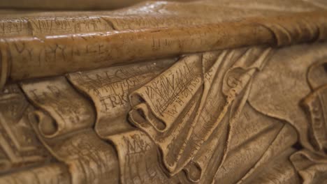 Close-up-on-one-of-the-vandalised-effigies-of-the-Saxon-bishops-of-the-wells-cathedral,-camera-rotating-to-the-right-showing-the-vandalised-parts-of-the-effigy