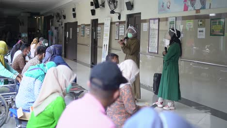 Grupo-De-Ancianos-Asiáticos-Sentados-En-Fila-En-El-Pabellón-Del-Hospital-Y-Escuchando-A-La-Enfermera-Durante-La-Sesión-De-Terapia