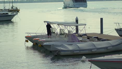 Marinero-Limpiando-Un-Pequeño-Bote-En-Un-Muelle-De-Un-Pequeño-Puerto