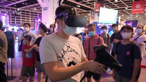 Un-Jugador-Chino-Juega-Un-Videojuego-De-Disparos-Multijugador-De-Realidad-Virtual-Mientras-Los-Visitantes-Lo-Ven-Jugar-Durante-El-Festival-De-Computadoras-Y-Comunicaciones-De-Hong-Kong-En-Hong-Kong