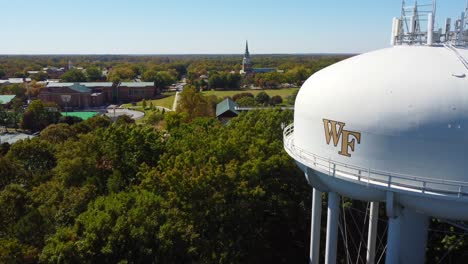 Torre-De-Agua-En-El-Campus-Universitario-De-Wake-Forrest-Con-Capilla-De-Espera-En-El-Fondo,-Winston-Salem,-Nc