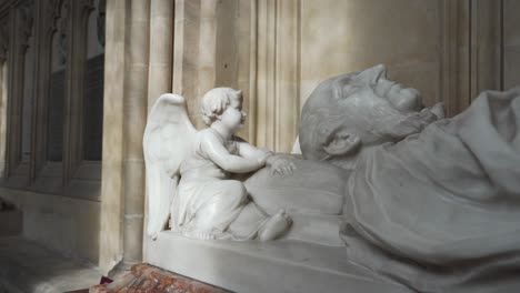 Close-up-on-one-of-effigies-of-one-of-the-Saxon-bishops-of-the-wells-cathedral,-camera-rotating-to-the-right-showing-the-face-and-the-angel-of-the-effigy