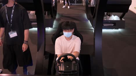 A-Chinese-gamer-plays-a-themed-racing-videogame-as-visitors-attend-the-Hong-Kong-Computer-and-Communications-Festival-in-Hong-Kong