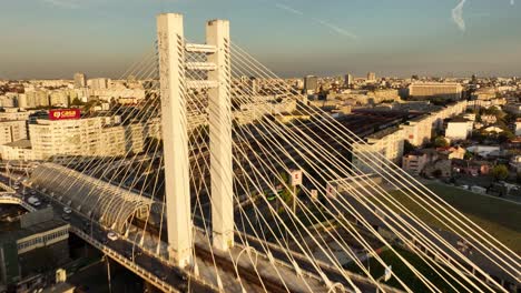 Aerial-flight-over-golden-Basarab-Bridge-with-traffic-in-city-of-Bucharest-during-golden-sunset