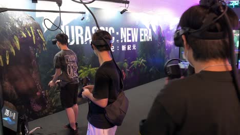 Jóvenes-Jugadores-Chinos-Juegan-Videojuegos-De-Disparos-De-Realidad-Virtual-Mientras-Recargan,-Apuntan-Y-Disparan-A-Objetivos-Durante-El-Festival-De-Comunicaciones-Y-Computación-De-Hong-Kong-En-Hong-Kong