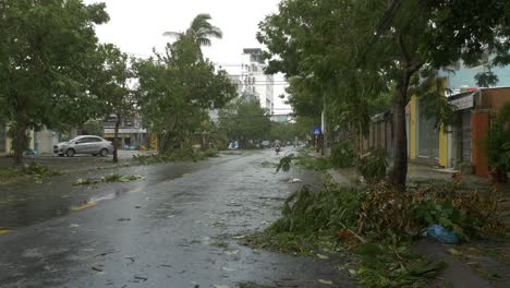 Calles-Mojadas-De-La-Ciudad-Y-Ramas-De-árboles-Rotas-Después-Del-Tifón-Tropical,-Pasando-Motos