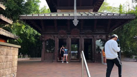 Handheld-point-of-view-shot-walking-towards-the-three-story-high-nepalese-pagoda-in-South-Bank,-tourists-visiting-the-attraction-at-heart-of-the-Parklands,-South-Bank-Brisbane,-Queensland,-Australia