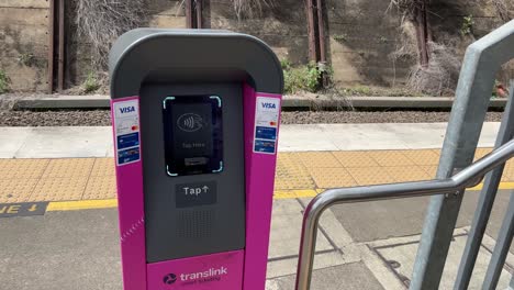 Male-passenger-tapping-on-at-the-ticketing-machine-at-Bowen-Hills-train-station,-using-go-card-to-pay-for-the-trip,-Brisbane-Queensland,-Australia