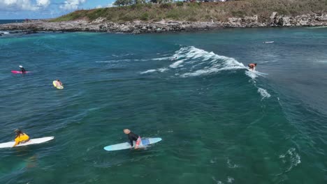 Surfer-Paddeln-Hinaus,-Setzen-Sich-Auf-Ein-Surfbrett,-Lesen-Den-Ozean,-Um-Das-Nächste-Set-Zu-Fangen,-Hookipa-Maui