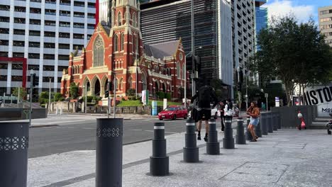 Young-athletic-man-standing-and-jumping-on-the-public-pole,-parkour-activity-captured-in-downtown-Brisbane-city