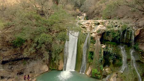 Group-Of-People-Enjoying-The-View-Around-The-Waterfalls-Taking-Pictures,-And-Others-Enjoying-A-Swim-At-Cascada-de-Comala-Park-Near-Chiquilistlán,-Jalisco,-Mexico