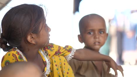 Close-up-video-of-the-small-girl-turning-her-head-to-look-at-the-small-child-who-is-looking-directly-at-the-camera