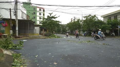 Secuelas-De-La-Tormenta-Tropical,-árboles-Y-Hojas-En-Las-Calles-De-La-Ciudad-Y-Motociclistas-Que-Pasan